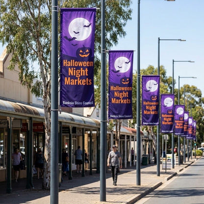 Purple Halloween Night Markets street flags on a row of poles along an Australian main street, 1000 x 3000mm council street flags