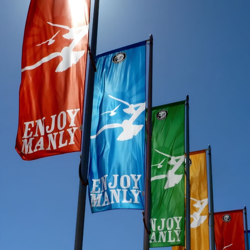 Council street flags flying from street poles, vertical event flags in red, blue, green and yellow with loops and top rod pocket